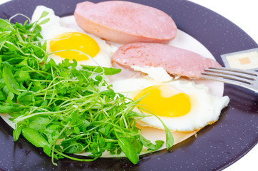 Fried eggs, sausages, fresh green salad, breakfast.