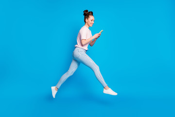 Fototapeta na wymiar Full length body size view of her she nice attractive pretty focused cheerful cheery girl jumping using cell app 5g blogging chatting isolated on bright vivid shine vibrant blue color background