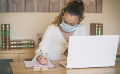 Woman teleworking at home because of coronavirus. Woman working with sanitary mask. Teleworking. Covid 19