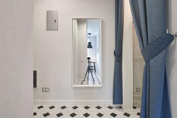 Compact entrance hall with open shelves and a full-length mirror in a classic style