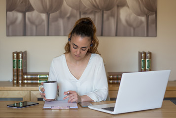 Woman having a cup of coffee while working from home. Teleworking. Covid 19