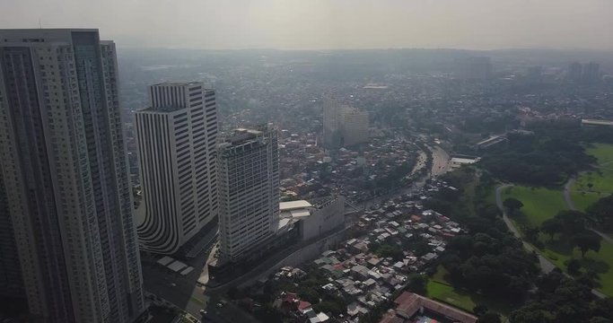 Descending aerial flight alongside modern building to reveal city capital's skyline. Drone, 4K.  

Frame rate: 23.98
Video Codec: ProRes 422HQ
Bonifacio Global City, BGC
Manila, Philippines