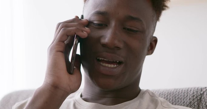 Sad black guy talking with girlfriend by mobile phone, close up