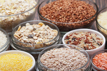 A set of bowls filled with different seeds: buckwheat, rise, corn and oatmeal