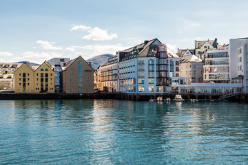 Obraz premium Alesund, Norway - June 2019: View of colorful Art Nouveau architecture in the port of the city of Alesund, Norway. Panoramic view of Alesunds architecture and docked sailing boats and vessels.