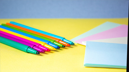 Colored felt-tip pens and multi-colored stickers on a light background
