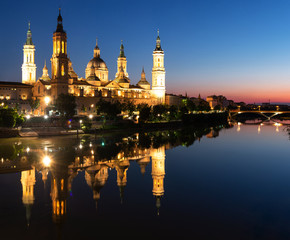 Illuminated Basilica of Our Lady of the Pillar on the banks of the Ebro at sunset in Zaragoza, Spain