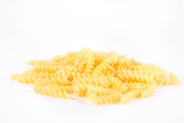 Raw fusilli pasta on a white background