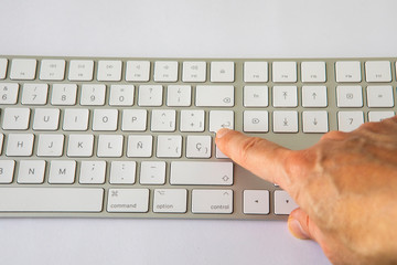 finger touching a key on a keyboard