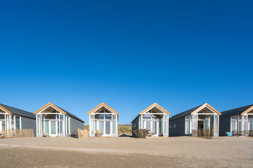 Empty beach houses cabins along the shore and on the beaches are empty.