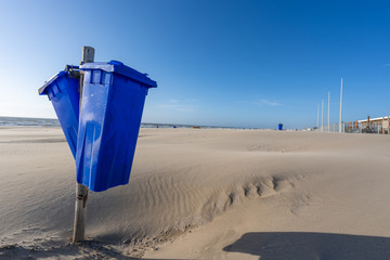 Blue trash cans dustbin on an empty beach