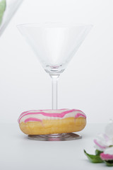 a glass of martini and a pink and white striped donut close-up. photo for the screensaver. - 353353301