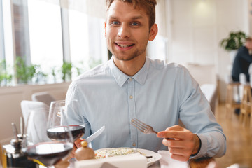 Fototapeta na wymiar Handsome young man spending time in restaurant