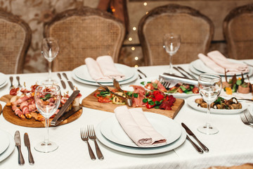 Empty dishes set in restaurant. white tablecloth on the table