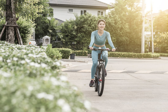 Young sporty woman riding a bicycle in the morning city at sunrise. Sport lifestyle concept.