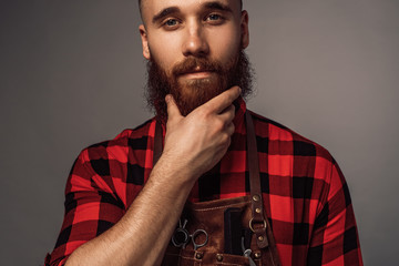 Crop stylish hairdresser stroking beard