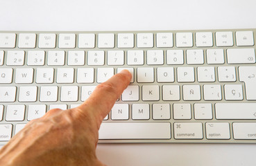 finger touching a key on a keyboard