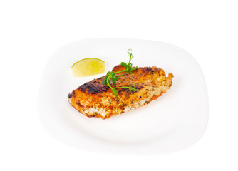 Piece of fried chicken with spices on white plate.