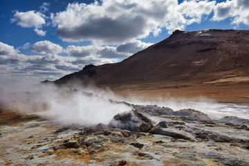 Natural steam rising from volcanic vents in the earth. Namafjall - geothermal area in field of...