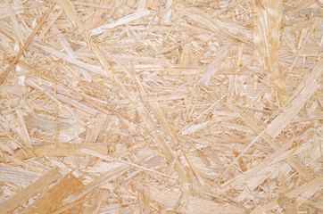 OSB for construction work. Oriented particle board. Wood background. Background from shavings. Wooden texture.