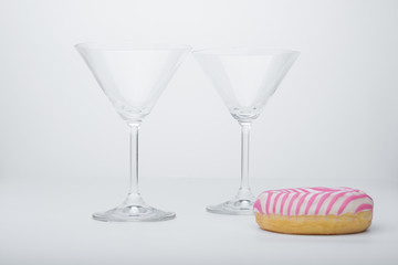  a glass of martini and a pink and white striped donut close-up. photo for the screensaver. - 353355790