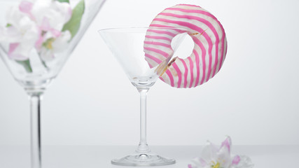  A flower in a glass close-up for a screensaver. In the background is a donut glass. And next to it is a pink flower.