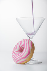  Martini glass and pink donut close-up. pink liquid is poured into the glass. photo for the screensaver. - 353356123