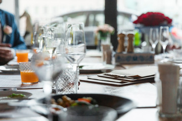 Glasses in bokeh and table setting in a restaurant