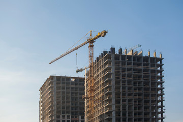 Construction site with cranes against the blue sky