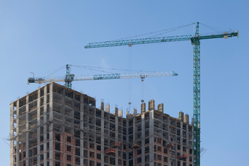 Fototapeta na wymiar Construction site with cranes against the blue sky