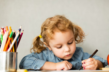 Cute European girl sits at school desk, concept of learning, back to school