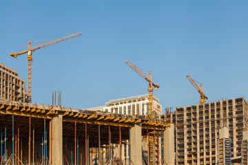 Construction site with cranes against the blue sky