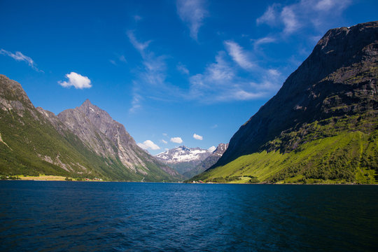Picturesque scene of Urke village and Hjorundfjorden fjord, Norway. Drammatic sky and gloomy mountains. Landscape.