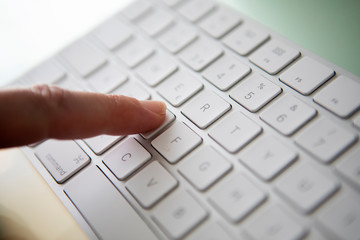 finger touching a key on a keyboard