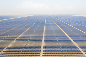 Aerial view of a landscape with photovoltaic solar panel farm producing sustainable renewable...