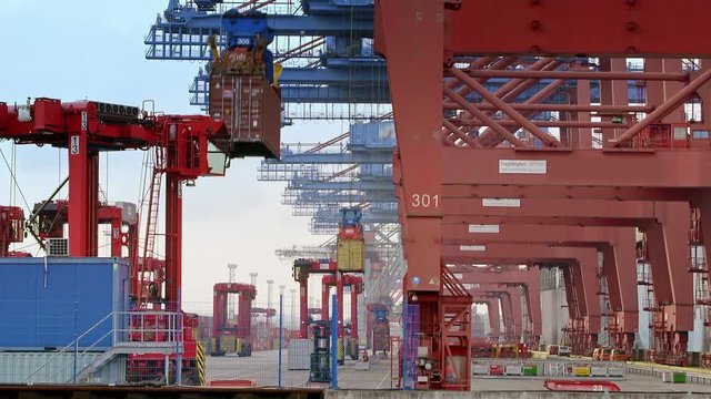 Gantry cranes are loading a container ship in the port of Hamburg / Germany. Two scenes - container are lifted up and placed on a ship