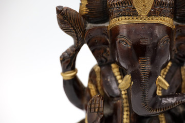 A wooden statuette of the Hindu deity Ganesh on a white background