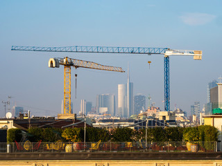 Dos enormes grúas en el paisaje urbano de Milan

