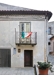 Ripacandida, Basilicata Italy. Balcony with italian flag on iron fence on old white house in small village in South Italy  