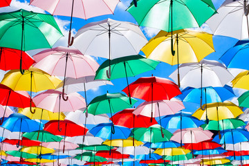 Fototapeta na wymiar Multicolored umbrellas on blue sky background