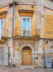 Fototapeta na wymiar Matera, Basilicata Italy. detail of old historical stone brick facade of a medieval house with balcony and wooden door at the entrance . 
