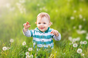 Happy child is smiling in green field of dandelions Carefree childhood