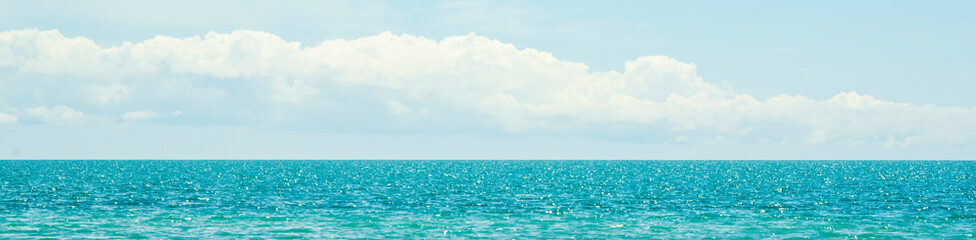 Fototapeta na wymiar Blue sky with clouds over blue sea, panorama