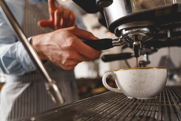 Fototapeta na wymiar Male barista making fresh coffee with professional machine