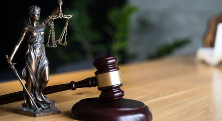 Law and Justice concept. Gavel of the judge, books, scales of justice. Gray stone background.