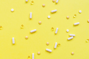 Pills capsules on yellow background.