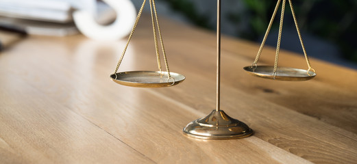 Law and Justice concept. Gavel of the judge, books, scales of justice. Gray stone background.