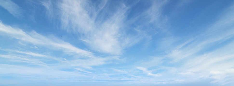 Blue sky with beautiful wispy clouds. Panoramic background.