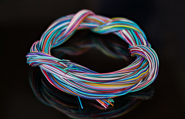 Electric cable harness of tangled colorful wires. Signal transmission. Round braided multicore...