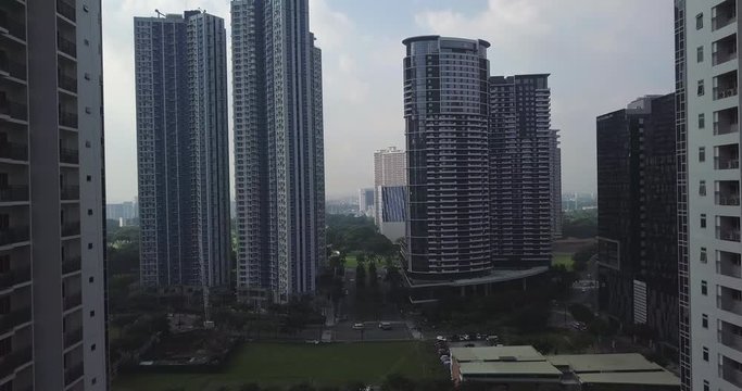 Descending aerial flight through newly developed area. High rise buildings. Drone, 4K. 

Frame rate: 23.98
Video Codec: ProRes 422HQ
Bonifacio Global City, BGC
Manila, Philippines